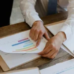 Tangan profesional menunjuk grafik kinerja dalam proses penilaian karyawan di kantor